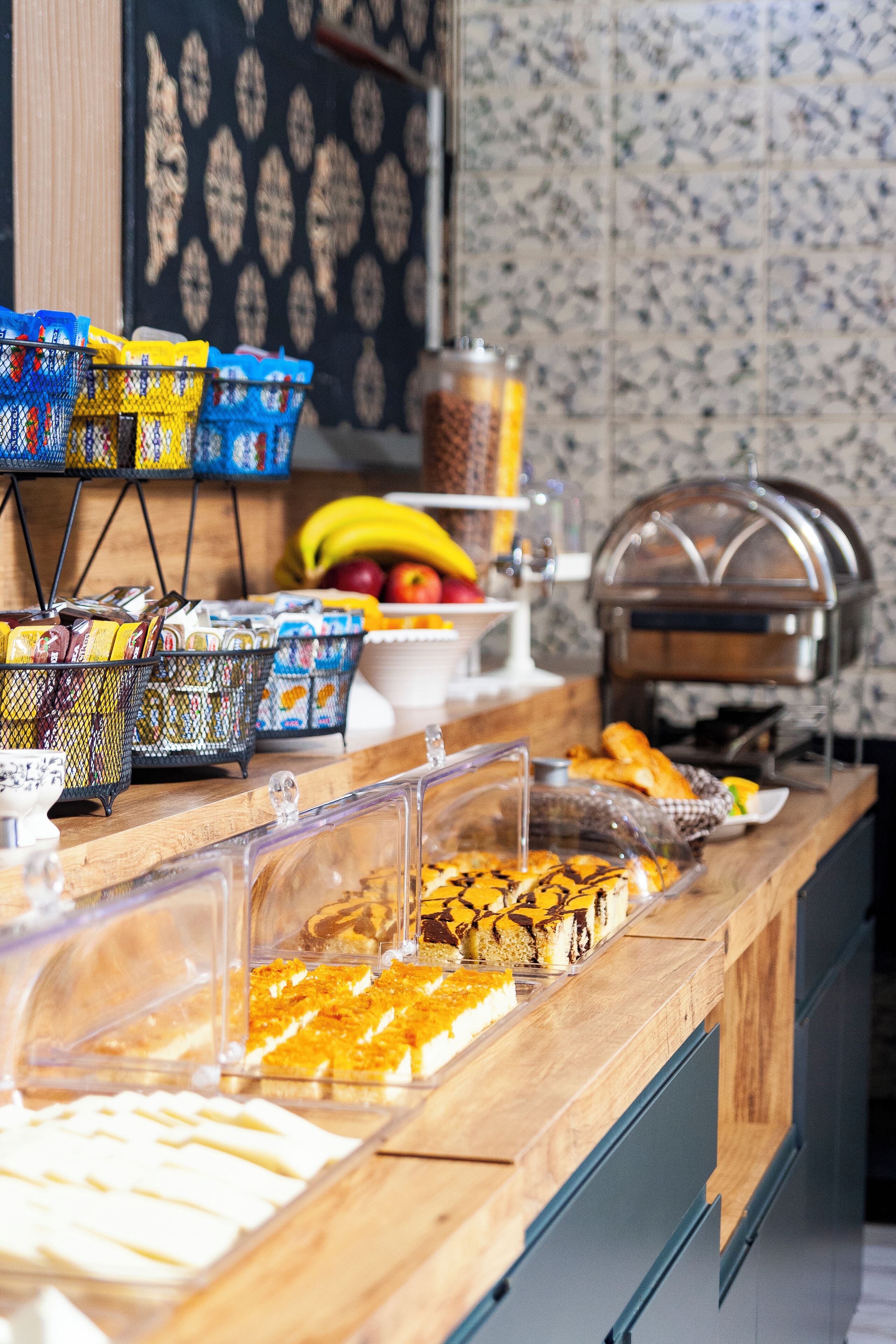 A buffet with various food items and baskets of snacks.