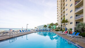 A swimming pool with lounge chairs and a view of the ocean. - Seas The Day Regency Towers 1122-Beachfront-Beautiful Decor. Fantastic Views! (Panama City)