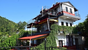 A multi-story building with balconies, a red awning, and a staircase leading to the upper levels.