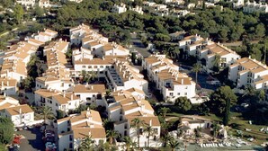 Un quartiere residenziale con diversi edifici bianchi, una piscina e aree verdi.