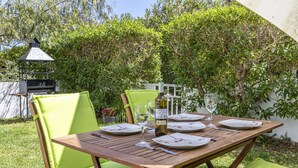 An outdoor dining area with a wooden table set for four, surrounded by green cushioned chairs. - VISTA MONTE ( Francisca ). Apartment in residentail area near The beach. (Puerto Pollensa)