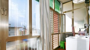 A laundry area with a washing machine, a small stool, and a basket on the counter. - Florence at one step, wifi internet, parking, A/C (Scandicci)