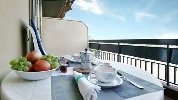 A balcony table with a bowl of fruit, a coffee pot, cups, and a rolled napkin. - Florence at one step, wifi internet, parking, A/C (Scandicci)