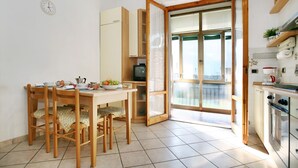 A kitchen with a dining table, chairs, a refrigerator, a stove, and a television. - Florence at one step, wifi internet, parking, A/C (Scandicci)