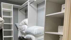 Un armario de vestidor con estantes abiertos, una barra para colgar y una escalera empotrada.