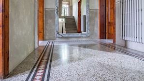 A hallway with a patterned floor, a large mirror, and a hanging light fixture. - Ancient Villa Art Nouveau original, large park and pool at 3 Km from Lucca Walls (Capannori)