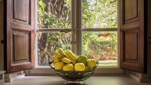 A window with wooden shutters, a basket of fruit, and a view of greenery outside. - Ancient Villa Art Nouveau original, large park and pool at 3 Km from Lucca Walls (Capannori)