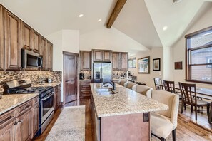 A modern kitchen with granite countertops, stainless steel appliances, and wooden cabinetry.