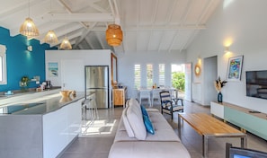 A modern kitchen with a central island, stainless steel appliances, and pendant lighting.