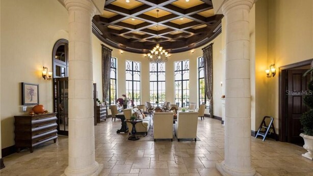 A spacious lobby with high ceilings, large windows, and a chandelier. - PARADISE MEETS PRIVACY WITH AMAZING WATER VIEW & HEATED POOL (Venice)