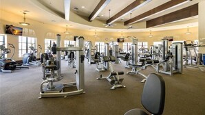 A spacious gym with various exercise machines, large windows, and a high ceiling. - PARADISE MEETS PRIVACY WITH AMAZING WATER VIEW & HEATED POOL (Venice)