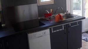 Une cuisine moderne équipée d’un four à micro-ondes encastré, d’un lave-vaisselle et d’une fenêtre située au-dessus de l’évier.