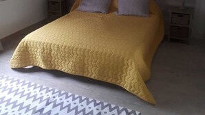 Une chambre à coucher avec un lit, deux tables de chevet, un miroir et un tapis à motifs.