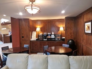 Relax in the hotel lobby, where a central table and chairs invite conversation, and a coffee station offers a selection of beverages.