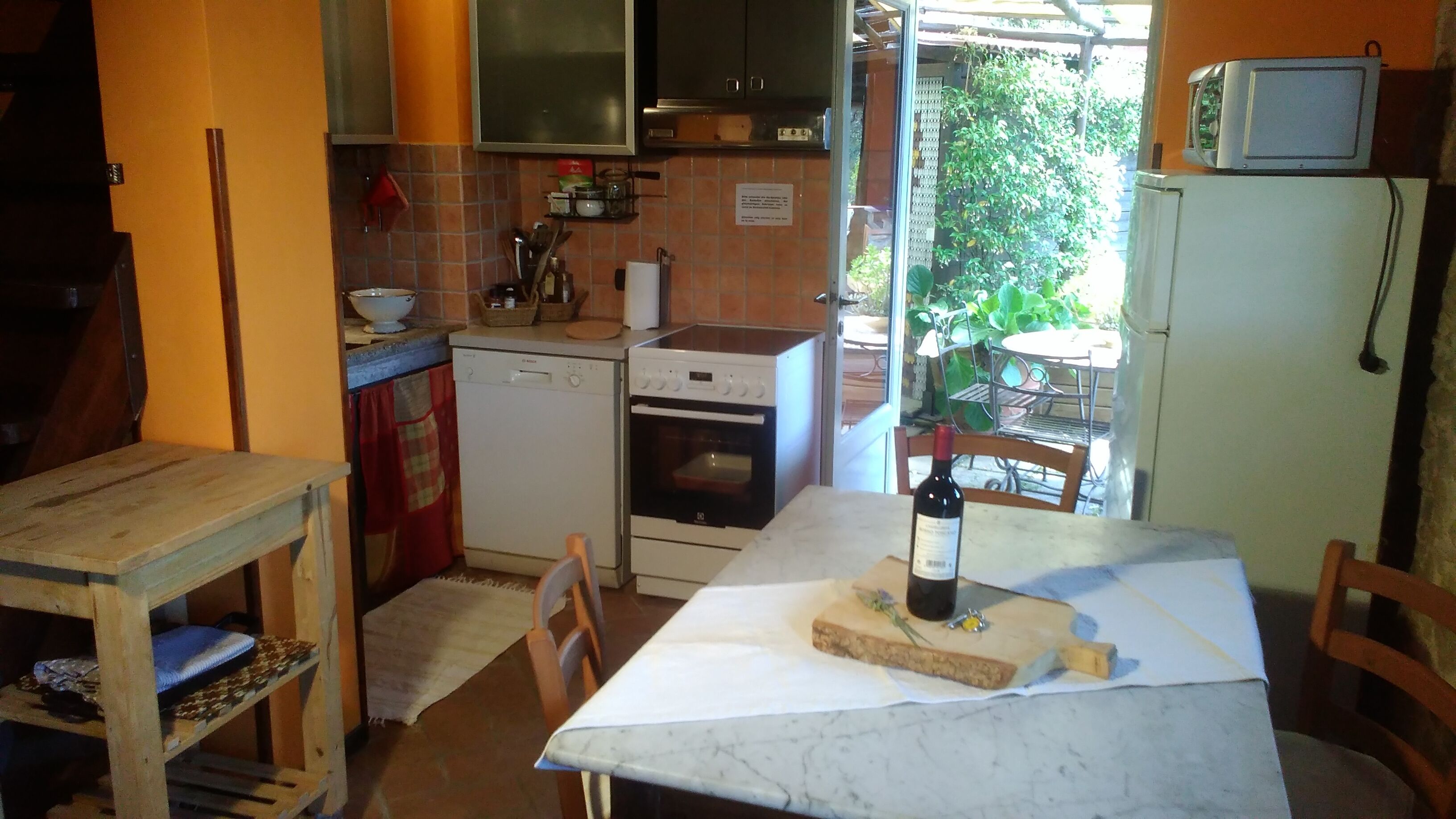 A compact kitchen with a dining area, a microwave, a dishwasher, and a refrigerator.