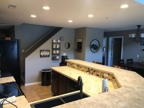 Enjoy cooking in this well-equipped kitchen with a central island, sink, and refrigerator.