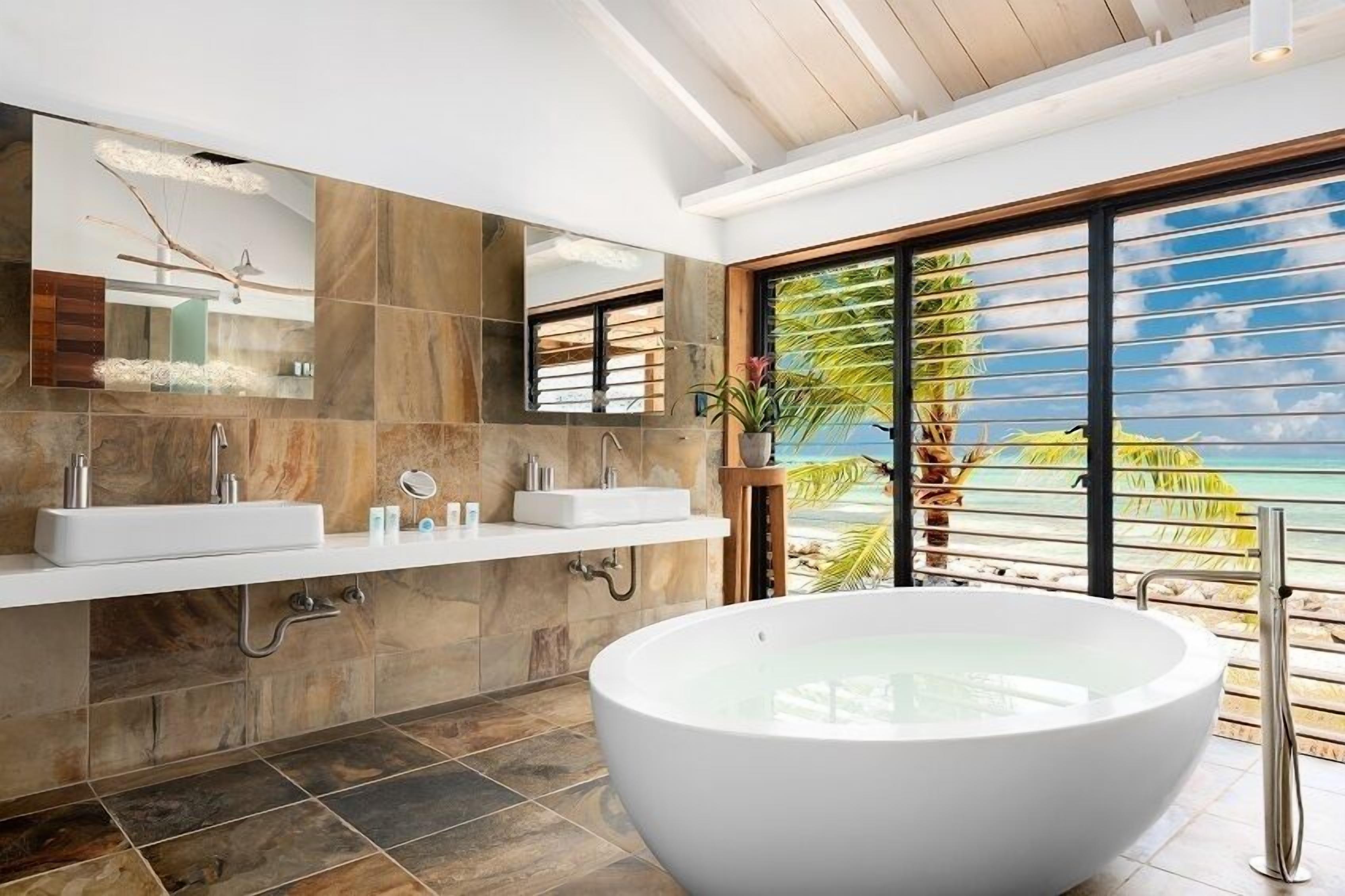A modern bathroom with a large freestanding bathtub, a double sink vanity, and a large mirror.