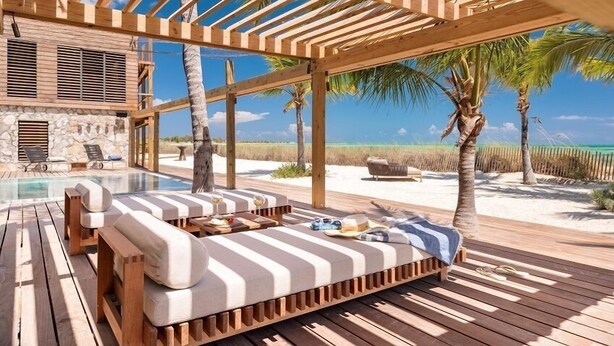 Eine Holzterrasse mit Pool, Liegestühlen und Blick auf Strand und Meer.