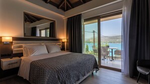 Un dormitorio con una cama grande, una mesita de noche, un espejo y vistas a un balcón con mobiliario exterior.