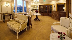 Un vestíbulo amplio con un gran ventanal, muebles elegantes y un candelabro.