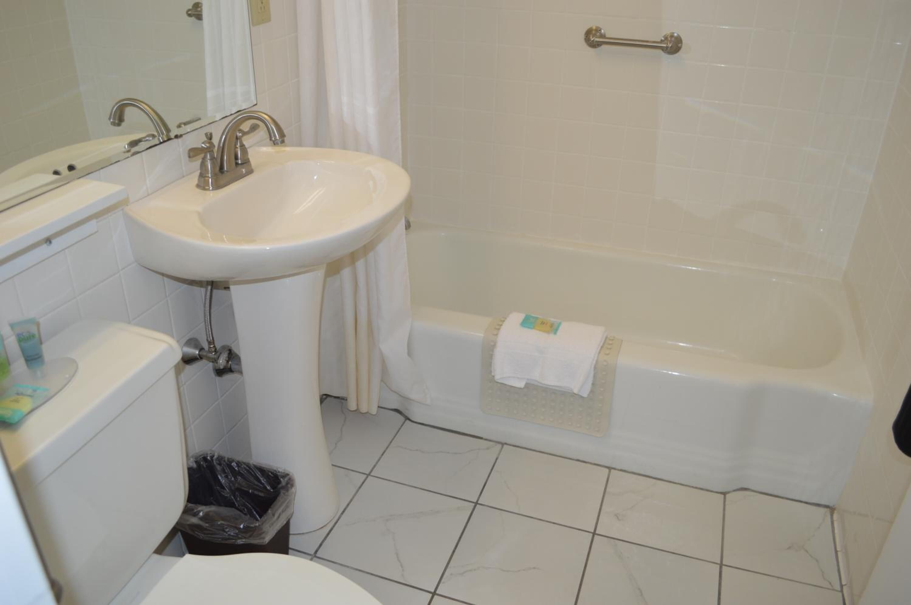 Un baño con lavamanos, inodoro y bañera.