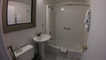 Une salle de bain avec des toilettes, un lavabo et une douche.