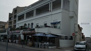 Ein mehrstöckiges Gebäude mit einem Restaurant im Erdgeschoss namens "Beach Corner".