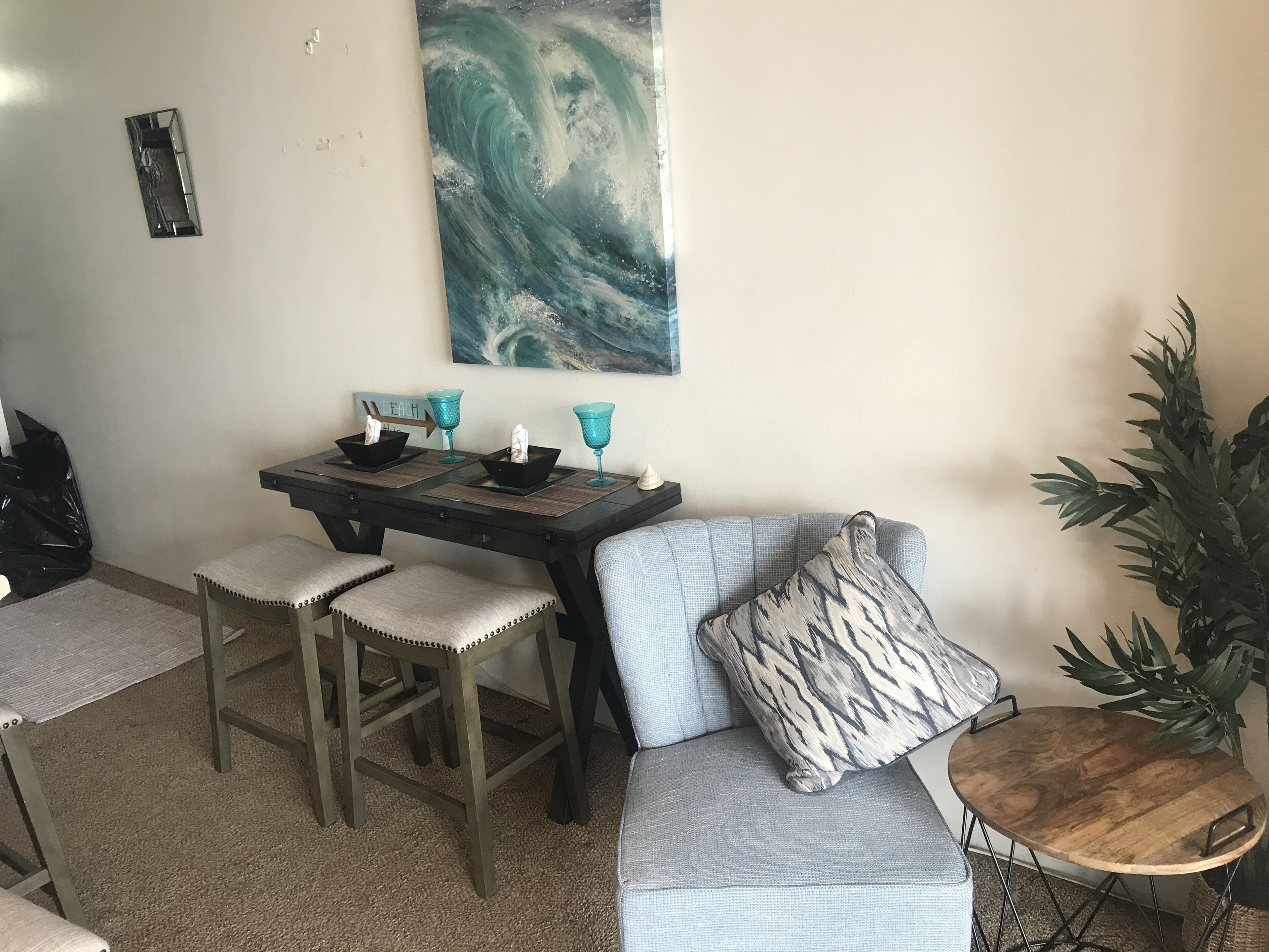 A dining area with a table, four chairs, and a sofa.