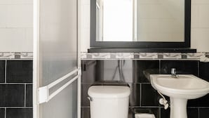 Une salle de bain avec des toilettes, un lavabo et un miroir.