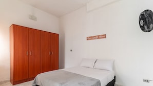 Une chambre à coucher comprenant un lit, une armoire et un panneau fixé au mur.
