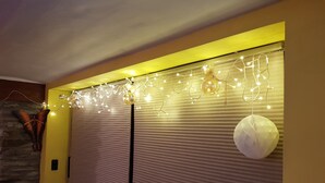 Habitació amb una porta corredissa tancada, una paret de pedra i llums decoratives penjades.