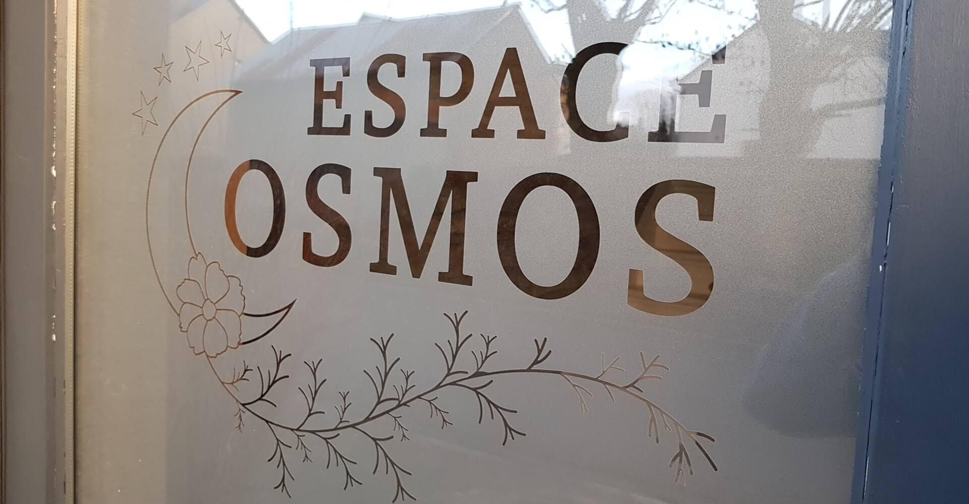 A sign with the words "ESPACE OSMOS" and a floral design.