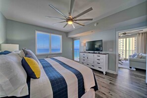 A bedroom with a bed, a ceiling fan, a TV, and a balcony with a view. - Shores of Panama 1529-End Unit~Sleeps 8 (Panama City Beach)