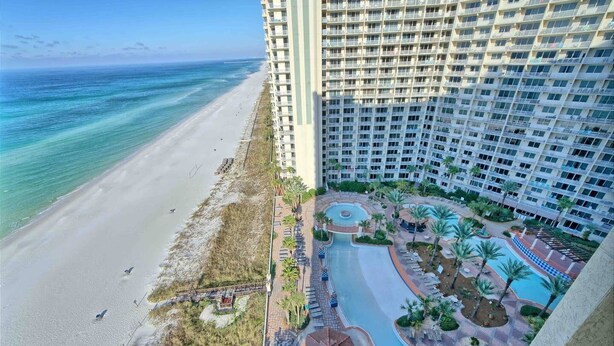 A high-rise hotel with a beachfront view, a swimming pool, and a landscaped garden. - Shores of Panama 1529-End Unit~Sleeps 8 (Panama City Beach)