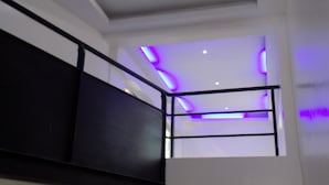 A staircase with a black handrail and white walls. - Posh Hotel And Suites (Lagos)