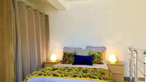 A bedroom with a bed, two bedside lamps, a wooden headboard, and a metal railing.