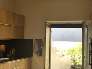 Una cocina con armarios de madera y vistas a un balcón sobre una masa de agua.