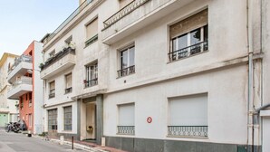 Un immeuble à plusieurs étages, doté de balcons, de fenêtres et d’un panneau indiquant qu’il est interdit de se garer.