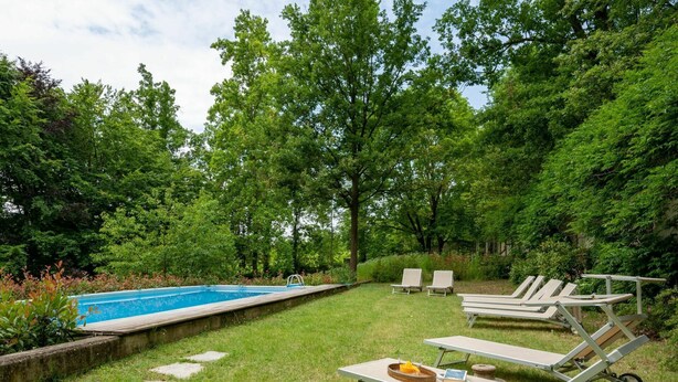 A backyard with a swimming pool, two lounge chairs, and a table with a basket and book. - Wonderful private villa for 12 guests with WIFI, private pool, TV, terrace and pets allowed (Valfenera)