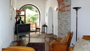 A cozy living room with a television, leather armchairs, and a coffee table. - Wonderful  villa for 4 guests with WIFI, pool, TV, terrace and pets allowed (Cigliè)