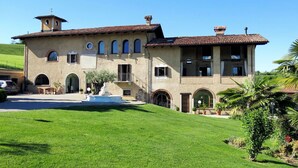A large, two-story building with a tiled roof, a fountain in the front courtyard, and a well-maintained lawn. - Wonderful  villa for 4 guests with WIFI, pool, TV, terrace and pets allowed (Cigliè)