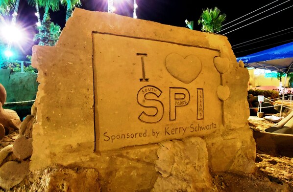 Una escultura de arena con el texto "I love SPI" y "Patrocinado por Kerry Schwartz".