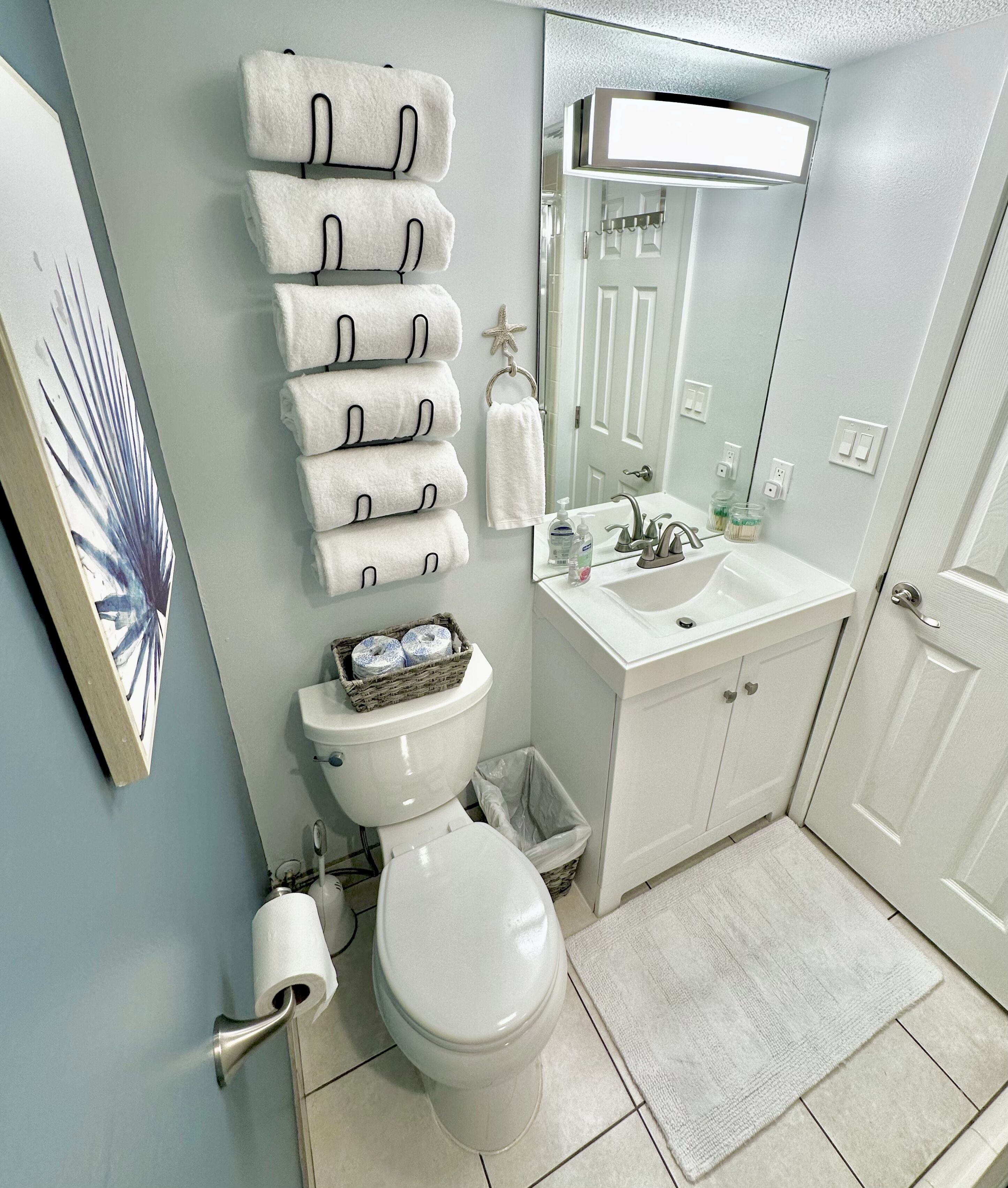 A bathroom with a toilet, sink, and towel rack.