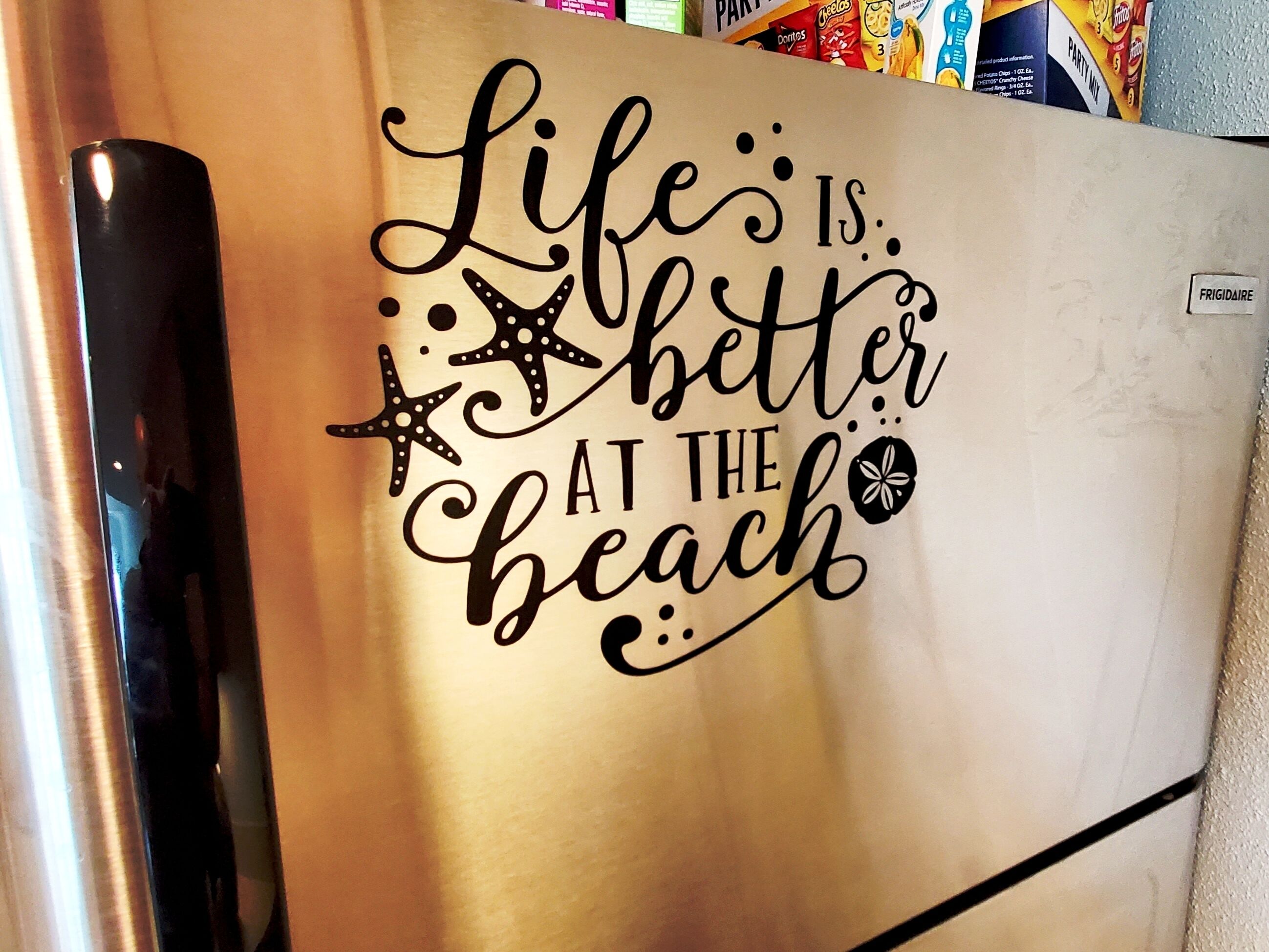 Un réfrigérateur agrémenté d’une citation inspirante et d’éléments décoratifs.