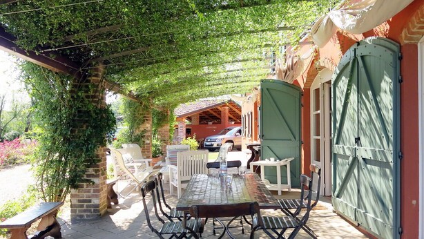 An outdoor patio with a table and chairs, a bench, and a green gate. - Stunning private villa for 10 guests with WIFI, private pool, TV, terrace and pets allowed (Capriglio)