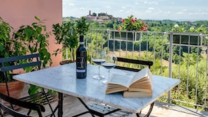 A terrace with a table, chairs, a bottle of wine, a glass, and an open book. - Stunning private villa for 14 guests with private pool, A/C, WIFI, TV, patio and panoramic view (Soglio)