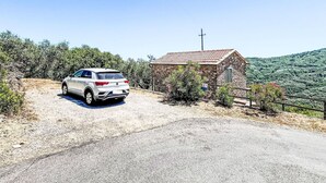 A white SUV parked on a gravel road beside a stone building with a cross on top, surrounded by greenery. - Beautiful private villa with WIFI, private pool, TV, terrace, pets allowed and panoramic view (Pietrabruna)