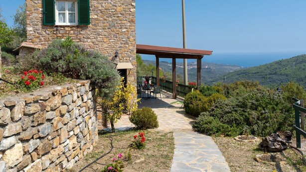 A stone house with a balcony overlooking a scenic view. - Beautiful private villa with WIFI, private pool, TV, terrace, pets allowed and panoramic view (Pietrabruna)