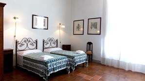 A room with two beds, a chair, and two wall-mounted lamps. There are framed botanical prints on the wall. - Cosy apartment in villa for 8 people with WIFI, pool, TV and panoramic view (Scarperia)