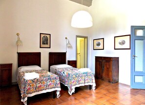 A room with two beds, a wardrobe, and a door.